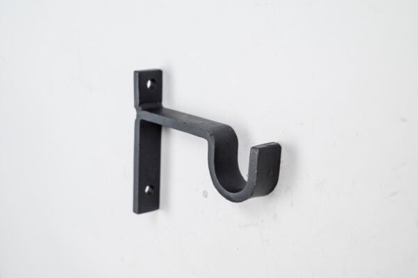 The Classic Center Support Bracket, with dual screw holes for rods or poles, is elegantly mounted on a white wall.