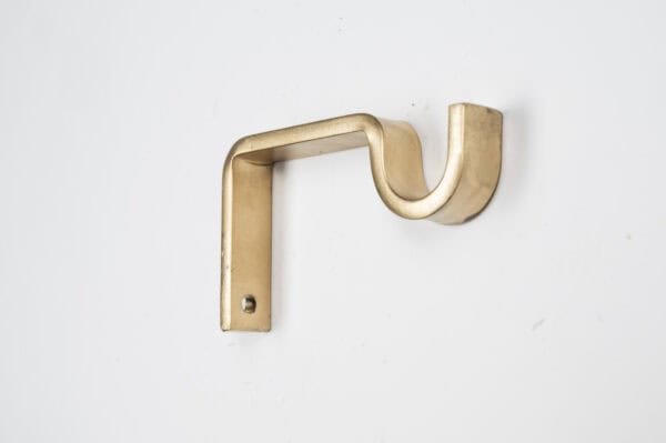 A gold wall-mounted Classic Center Support Bracket with a curved design against a white background.