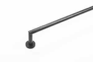A black metal curtain rod is mounted on a white wall, extending horizontally from a circular base.