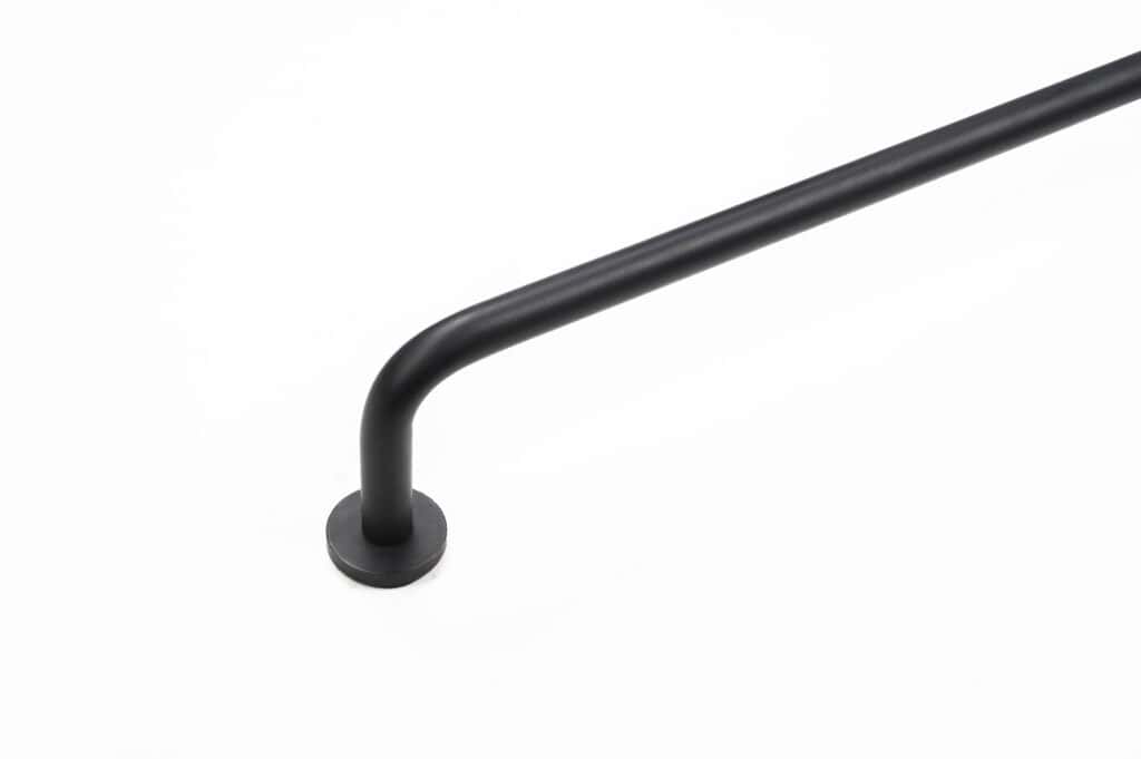 A black metal handrail mounted on a white wall, with a right-angle bend and a circular base attachment.