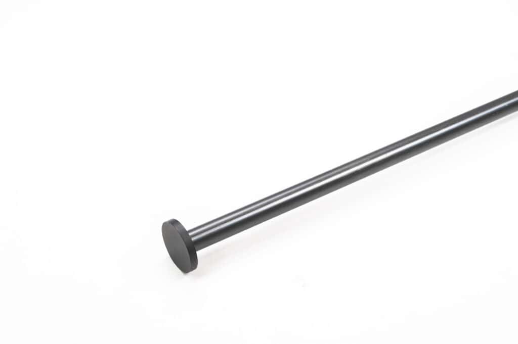 A black metal rod with a flat circular end positioned diagonally across a white background.