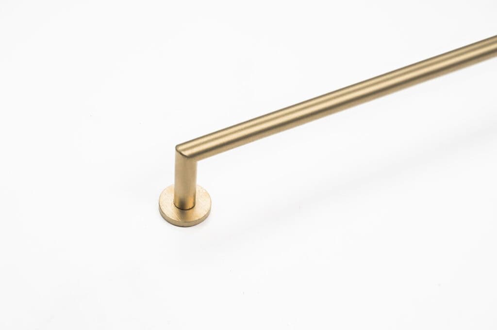 A single, straight, gold-colored metal rod is attached to a circular base on a white background.