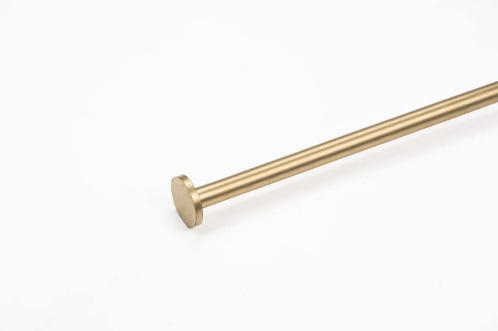 A single metallic curtain rod with a circular end, set against a plain white background.